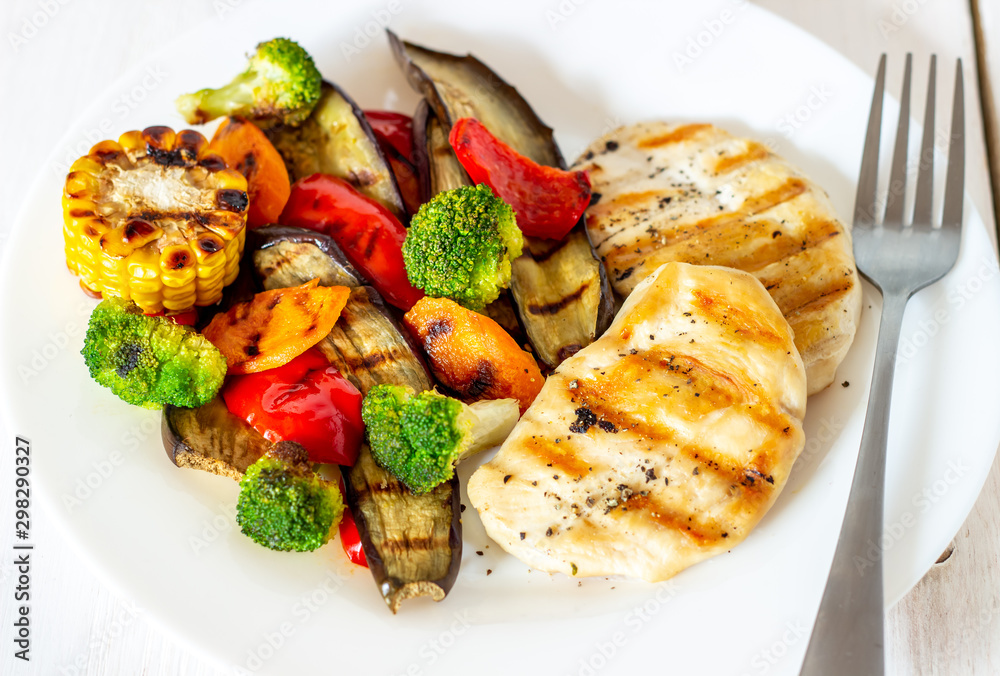 Grilled chicken with grilled vegetables on a wooden background. Healthy eating. Grilled chicken with grilled vegetables on a wooden background. Healthy eating.