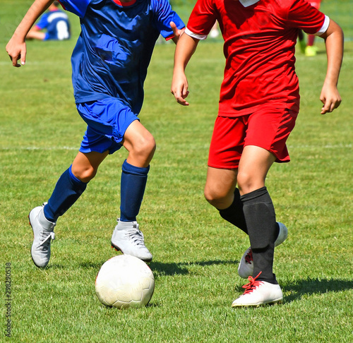 Fototapeta Naklejka Na Ścianę i Meble -  Young kids are playing soccer in summer time