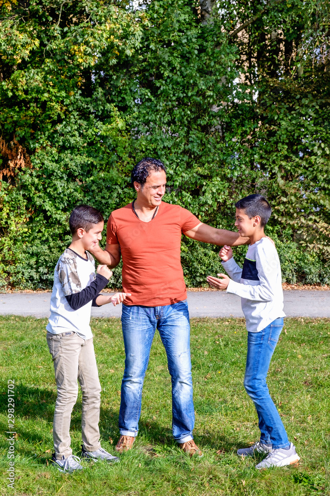 Father and teenage children in walking the park
