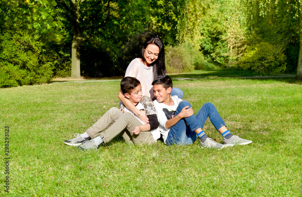 mother and teenage children in walking the park mother and teenage children in walking the park