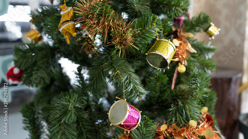 Decorate on a Christmas tree with a beautiful golden drum, blurred background.