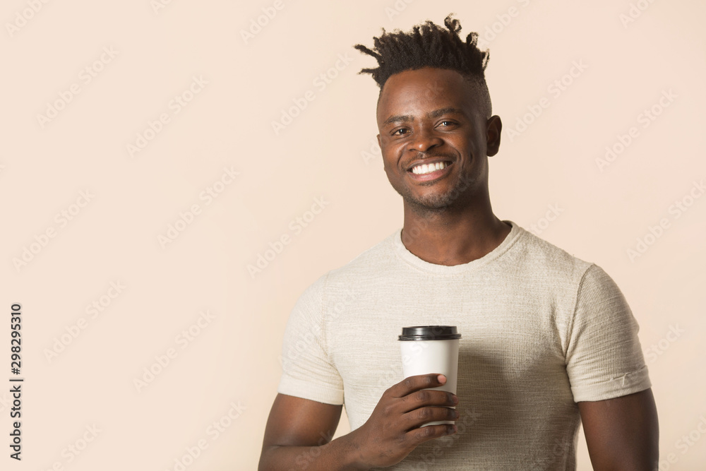 handsome young african man on a beige background with a glass of coffee in his hands handsome young african man on a beige background with a glass of coffee in his hands