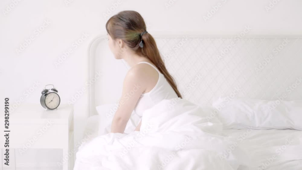 Beautiful young asian woman sleep and waking up in morning missed alarm clock with annoyed holding hand and unhappy, hurry wake late and delay with appointment on bedroom, lifestyle and time concept. Beautiful young asian woman sleep and waking up in morning missed alarm clock with annoyed holding hand and unhappy, hurry wake late and delay with appointment on bedroom, lifestyle and time concept.