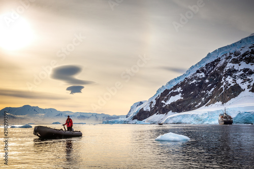 Zodiac boat and passanger cruise liner  in the snow fjord with glacier and icebergs, Neco bay, Antarctica photo