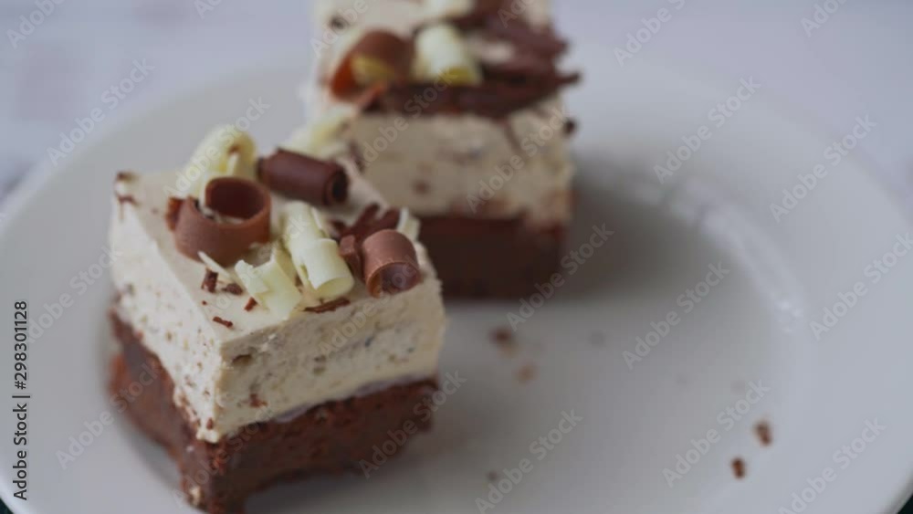 Person picking three chocolate cream desserts from a white plate, rotation Person picking three chocolate cream desserts from a white plate, rotation