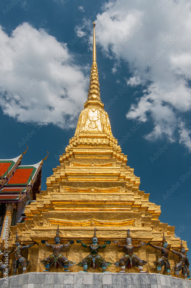 Fototapeta premium Demons guard the bottom of a gilded Phra Mondop at the temple of the Emerald Buddha (Wat Phra Kaeo), Grand Palace, Bangkok, Thailand.