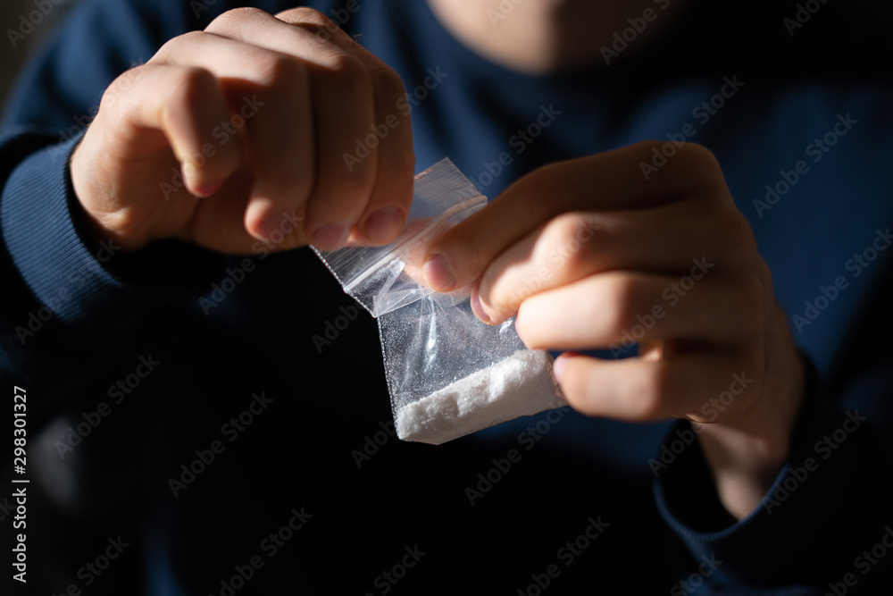 drug addict hands holding a small package with white powder drug addict hands holding a small package with white powder