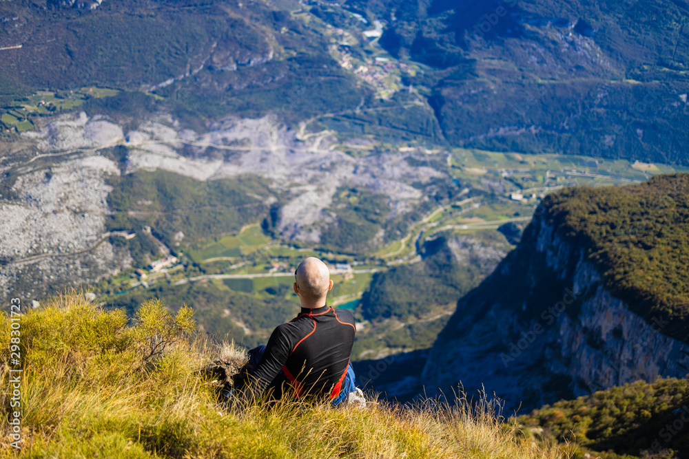 Traveler man sitting on a hill of beautiful alpine landscape
