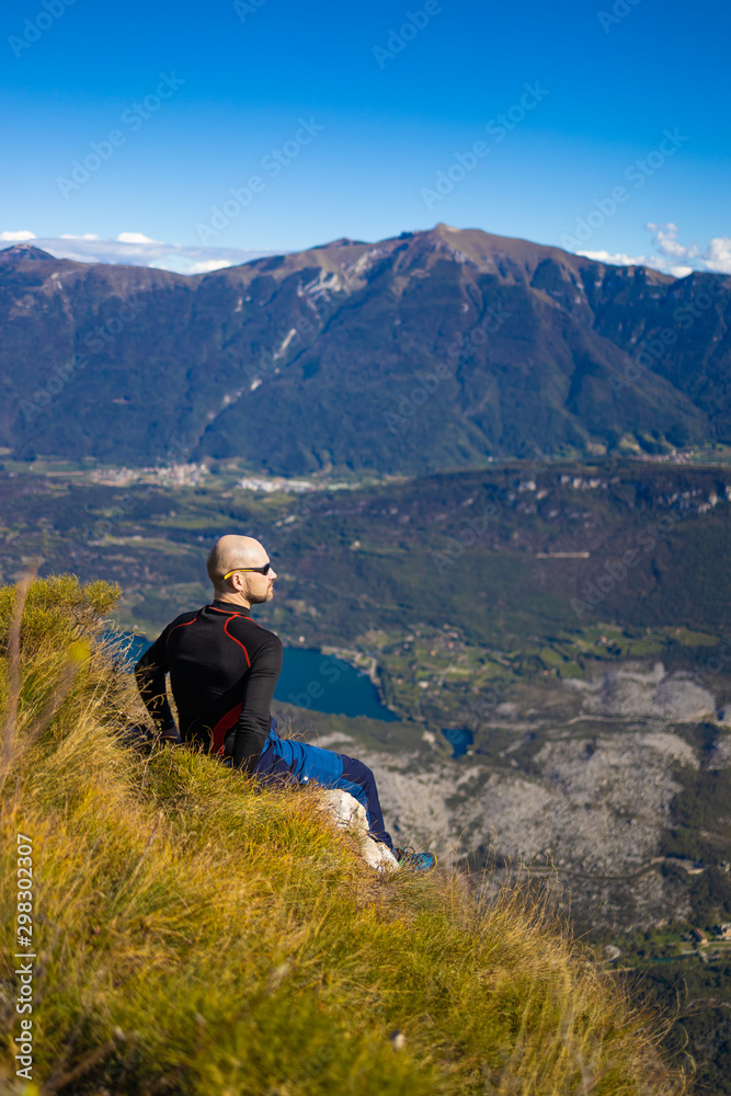 Traveler man sitting on a hill of beautiful alpine landscape