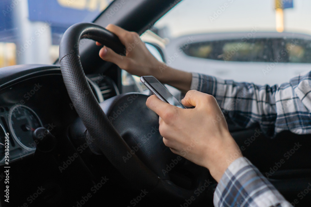 male driver in the vehicle using the smartphone, accident on the road