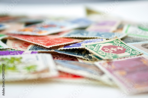 Closeup view on a variety of multi-colored postage stamps from different countries and years. Selective focus