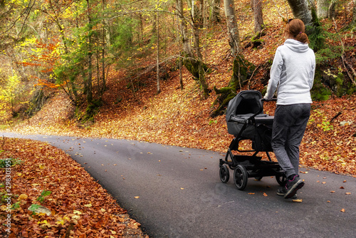 Woman with pram outside in forest photo