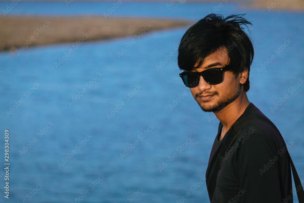 Indian male standing besides the lake Indian male standing besides the lake