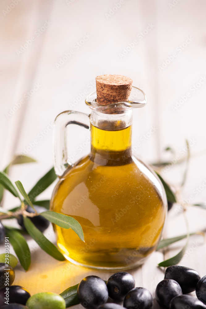 A table with a bottle of oil and mixed olives.