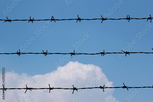 Barbed wire fence in front of the blue sky 