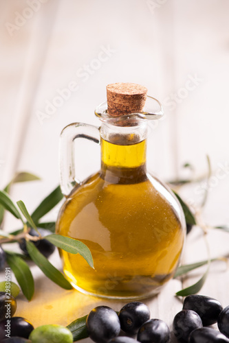 A table with a bottle of oil and mixed olives.