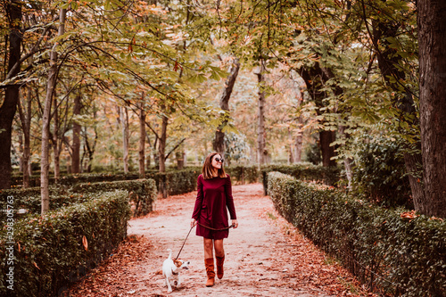 young woman and her cute jack russell dog walking in a park. Love for animals concept