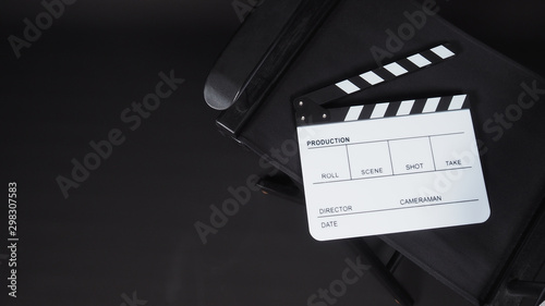 Clapperboard or clap board or movie slate with director chair use in video production ,film, cinema industry on black background.