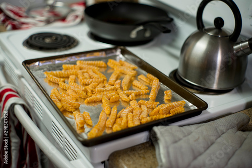 A baking sheet lined with foil, covered in frozen french fries, waiting to go in the oven