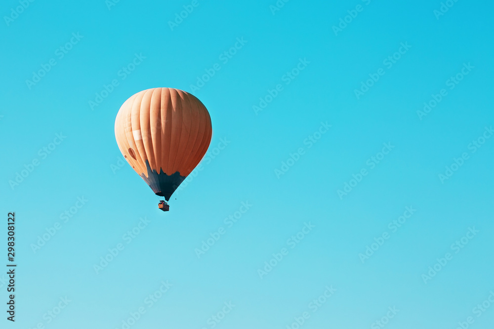Obraz premium Orange balloon soars against the blue sky