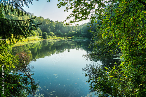 Fototapeta Naklejka Na Ścianę i Meble -  Beautiful calm lake and dark emerald forest ashore