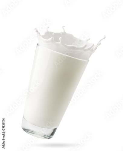 Stampa su Tela Glass of milk with splashes flies in the air on a white background, isolated