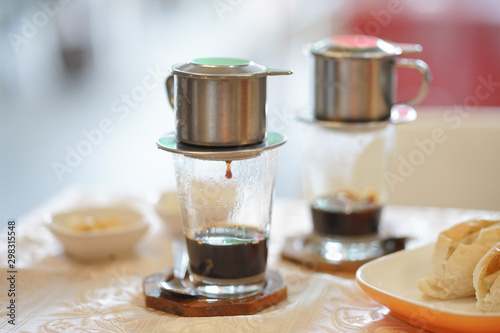 Drip coffee.  Breakfast set menu with Vietnamese dripping coffee served with buns. Soft focus.