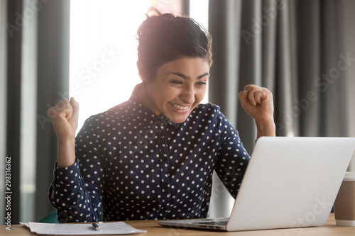 Excited indian employee receiving good news at office