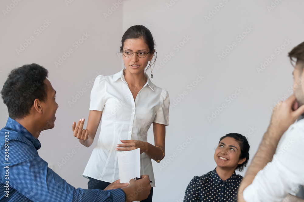 Young female team leader discussing project issues with coworkers Young female team leader discussing project issues with coworkers