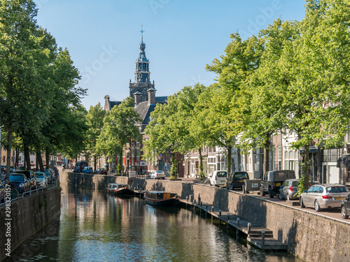 Canal and church tower in Gouda, Holland photo