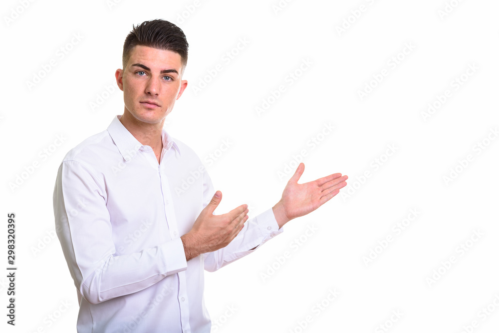 Studio shot of young handsome man showing something Studio shot of young handsome man showing something