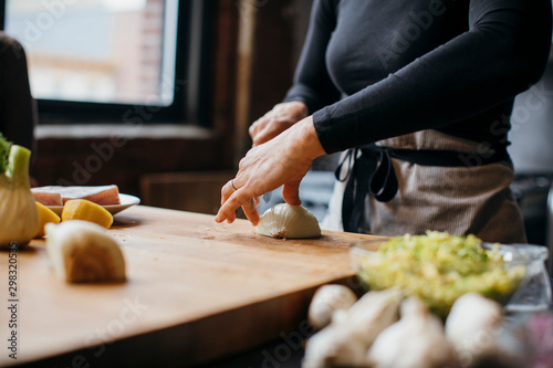 Vászonkép Midsection of female chef chopping onion on cutting board in training class