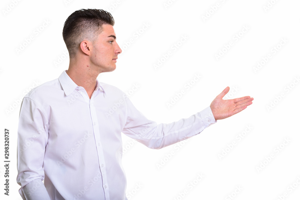 Profile view of young handsome man showing something Profile view of young handsome man showing something