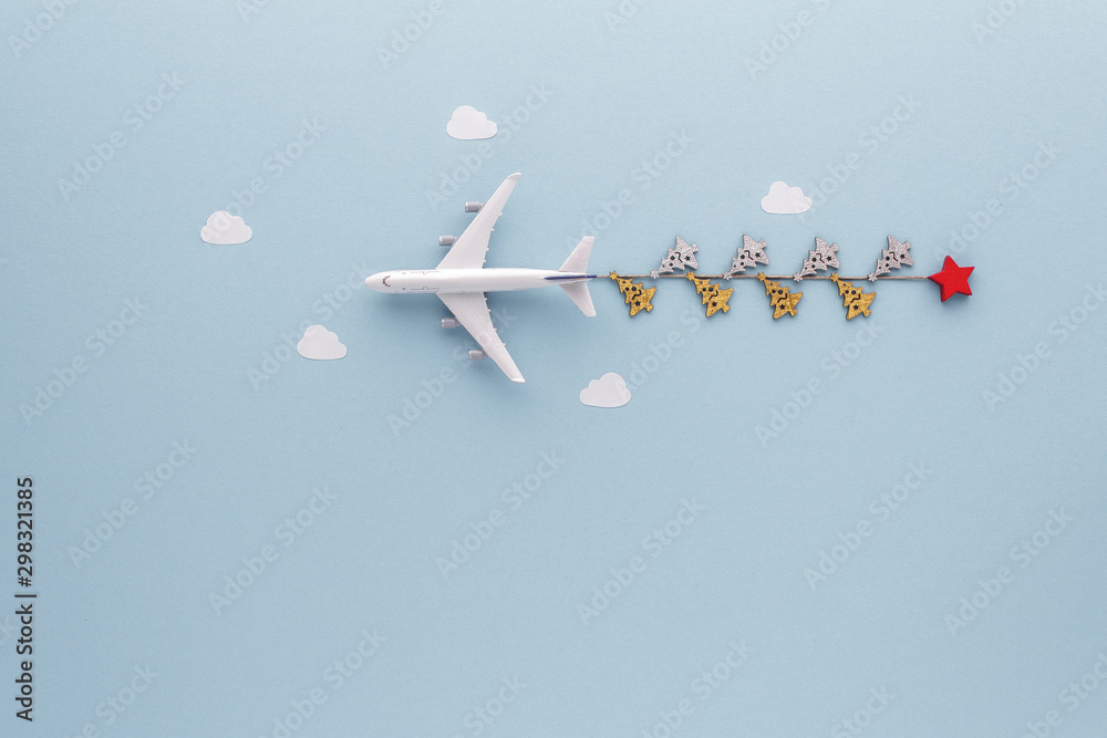 Fototapeta Christmas composition. Airplane flying in sky gift fir clouds top view background with copy space for your text. Flat lay.