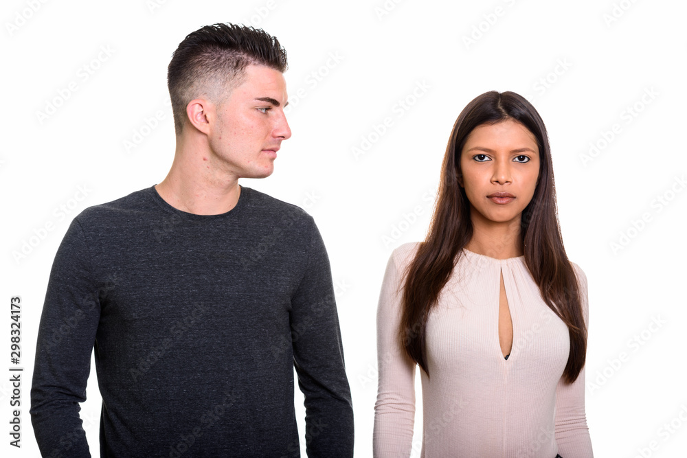 Man looking seriously to woman who looks into camera Man looking seriously to woman who looks into camera