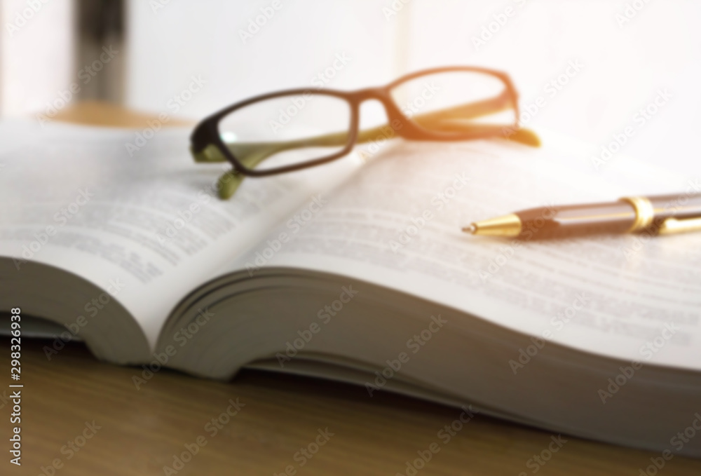 blur image of book ,glasses and pen , reading for the exam concept - obrazy, fototapety, plakaty 