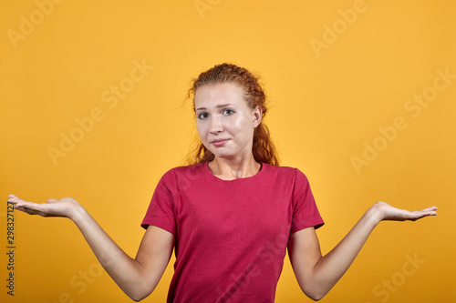Pretty, young woman holding her hands on the chest level showing gesture. Lady pretends that she is confused and puzzled. Model's long hair looks very healthy. Lady's eyes are of grey colour.
