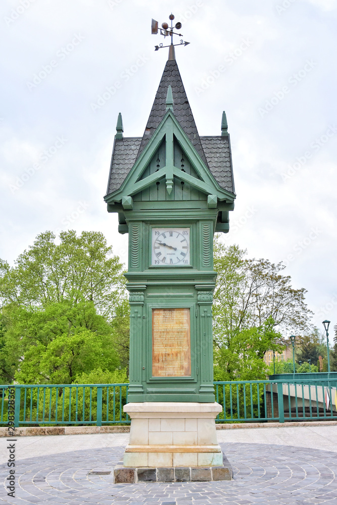 Gyor, Hungary - April, 2019. Unique city clock in a carved wooden frame. Gyor historical center, picturesque streets and colorful houses. Streets of Gyor old town with tourist attractions.