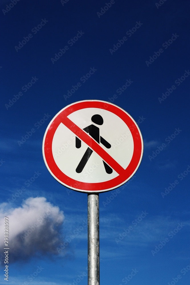 Road sign pedestrians are forbidden to pass with the sky