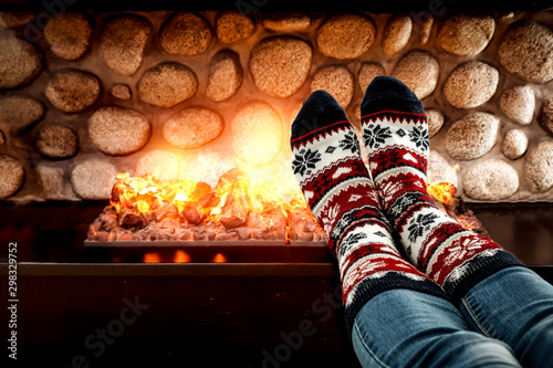 woman legs and fireplace in home interior 