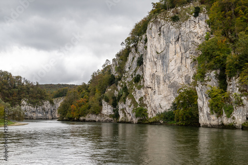 Danube river at Danube breakthrough near Kelheim, Bavaria, Germany in autumn with limestone rock formations and plants with colorful leaves