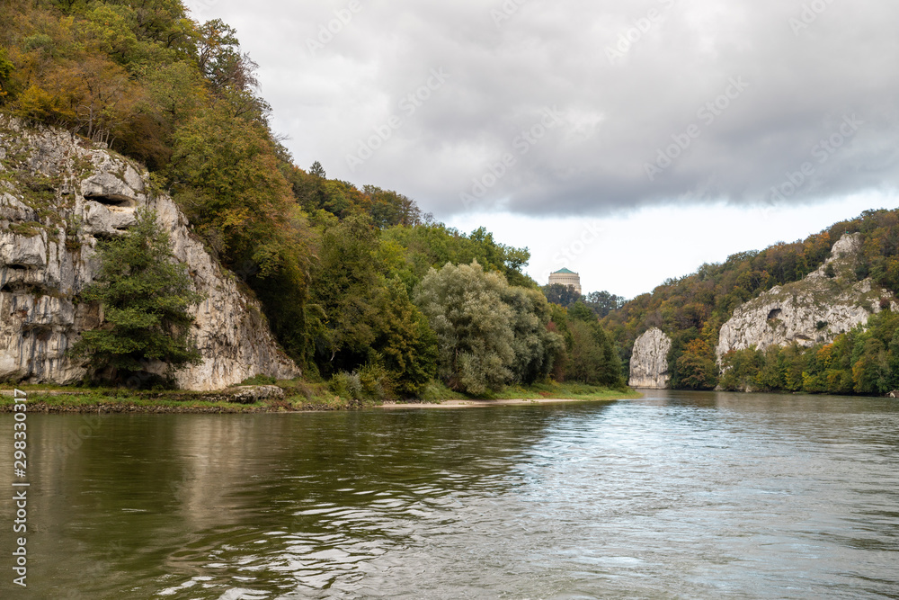 Fototapeta premium Nature reserve at Danube river breakthrough near Kelheim, Bavaria, Germany in autumn with limestone rock formations and Befreiungshalle on the Michelsberg in the background