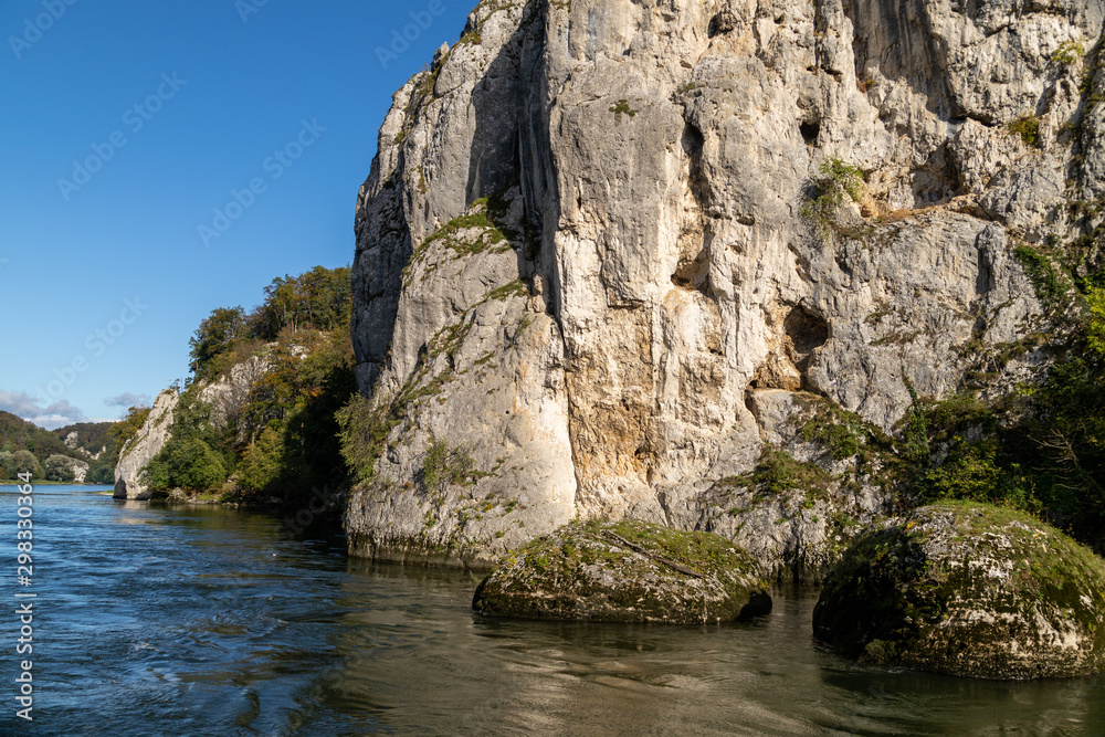 Danube river near Danube breakthrough near Kelheim, Bavaria, Germany in autumn with limestone rock formations and sunny weather with blue sky
