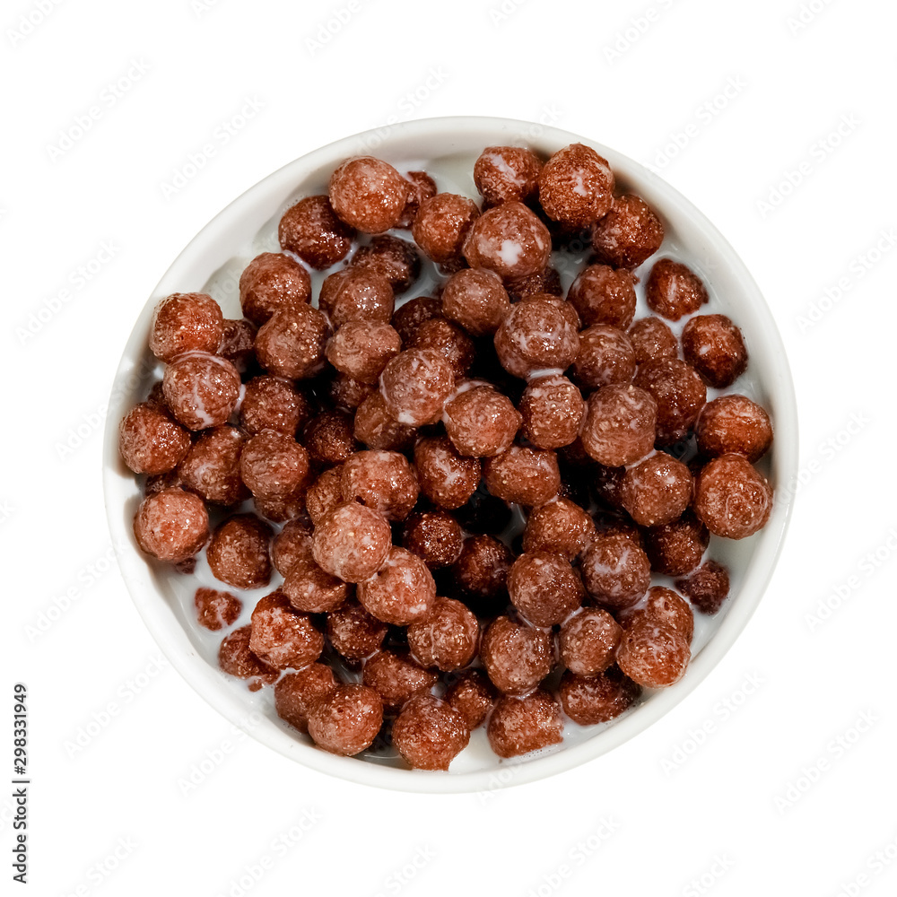Obraz premium Chocolate cereal balls with milk in a cup, top view