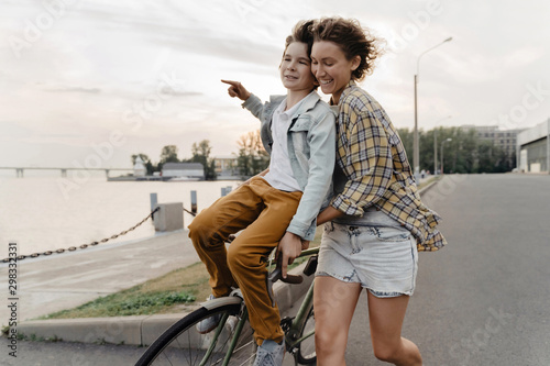Quadro su tela Young mother and son having fun while riding bicycle