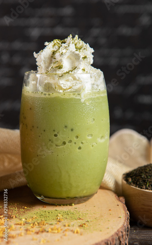 Εκτύπωση καμβά Green tea smoothie, decorate topping with whipping cream in a clear glass on a chopper with dark gray real wood floor