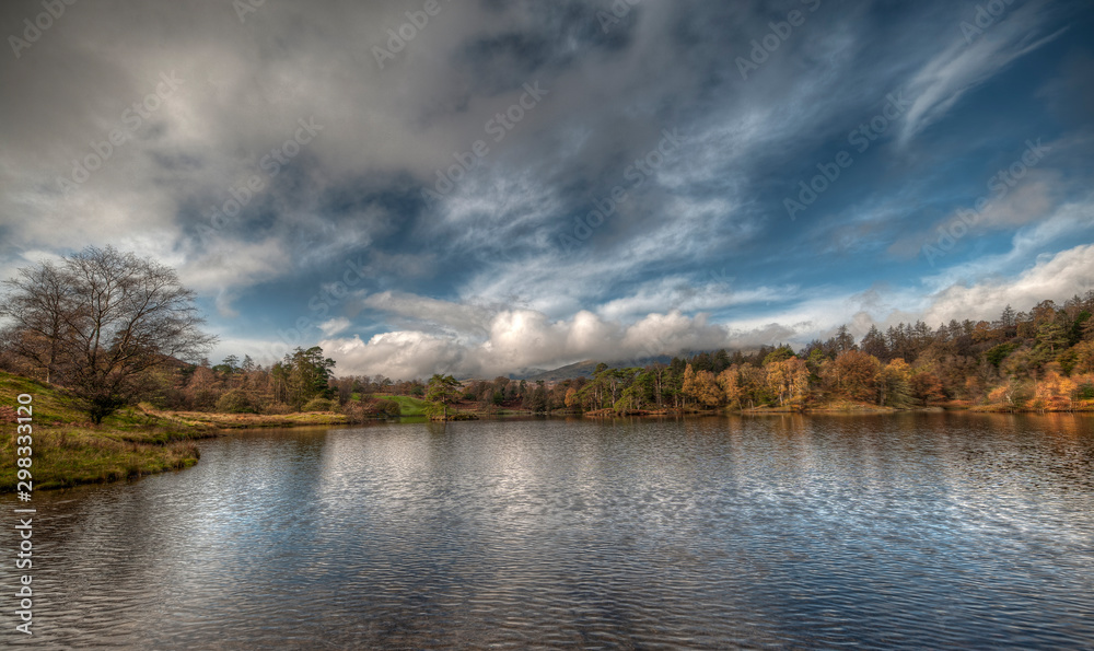 Stunning landscape image of Tarn Hows in Lake District during beautiful Autumn Fall.