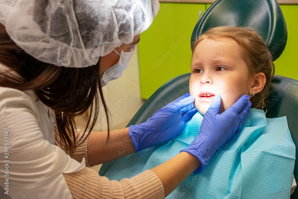 Little Caucasian girl treats teeth at the dentist Little Caucasian girl treats teeth at the dentist
