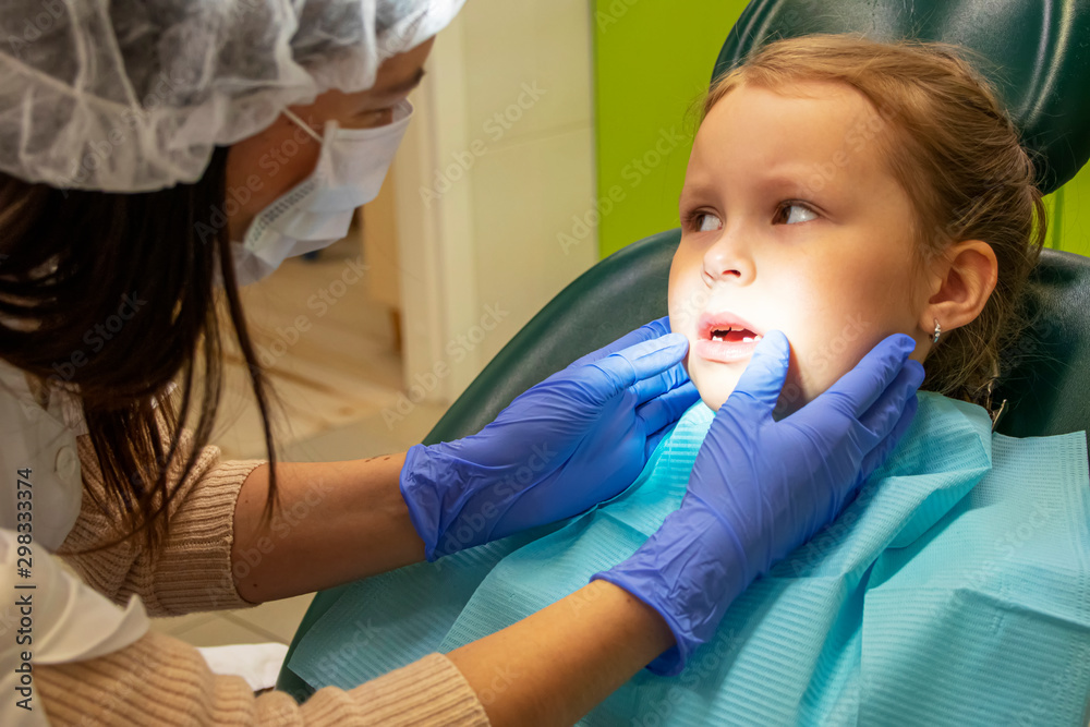 Little Caucasian girl treats teeth at the dentist Little Caucasian girl treats teeth at the dentist