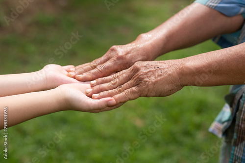 The hands of elderly stack on the hands of children. Showed the cooperate, love, care, charity of people with differences diversity for sustainability of farmer, community, society and the environment © sutlafk